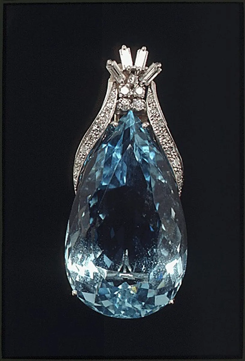 A faceted aquamarine gemstone set in a diamond pendant